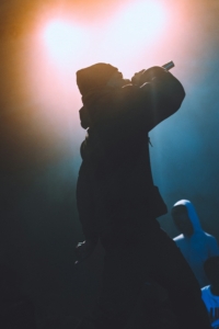 black silhouette of rapper singing in the microphone