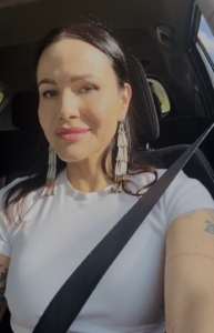 headshot of Eekwol. Indigenous woman with long black hair and long earrings that touches her shoulder