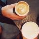 three people sitting around a table drinking coffee.