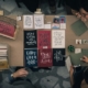 upper view of a table filled with home-made books and surrounded by people making them and looking at them