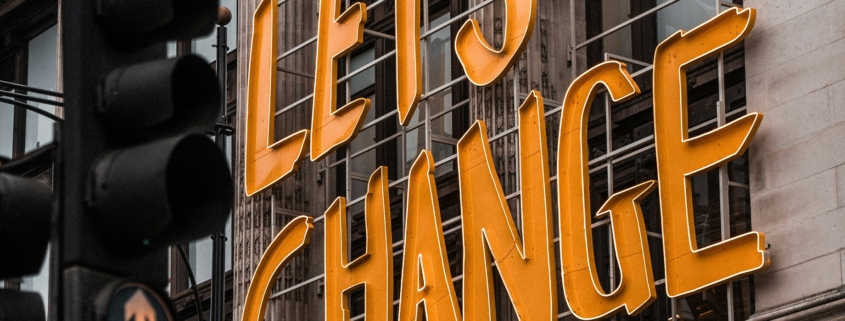 Street sign in orange that reads "Let's Change"