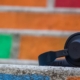 black headphones on a cement ledge in front of a wall of multi-coloured